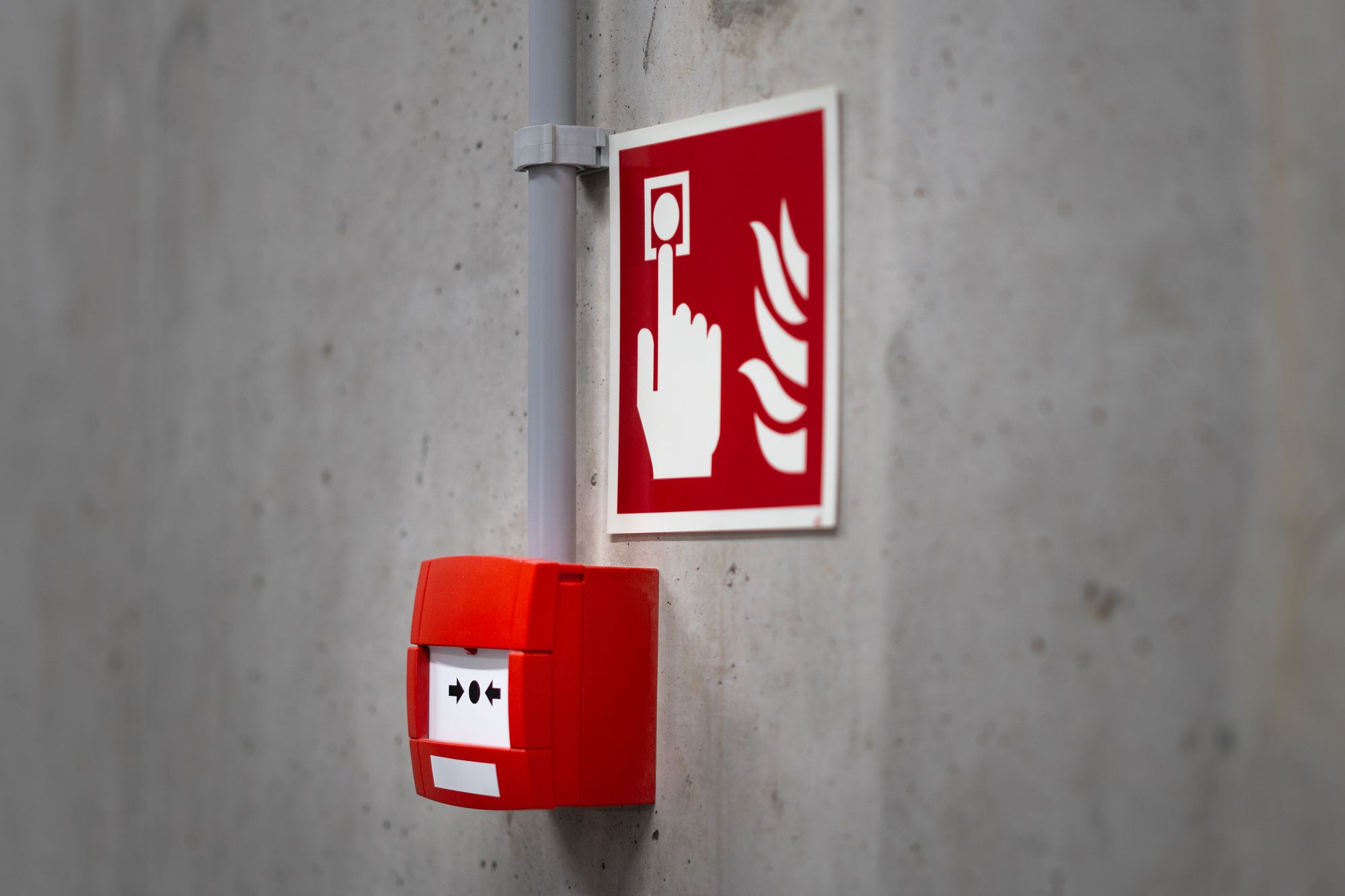 Estación manual de alarma contra incendio con su señal en un muro de concreto